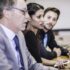 Businesswoman and businessmen listening in board meeting