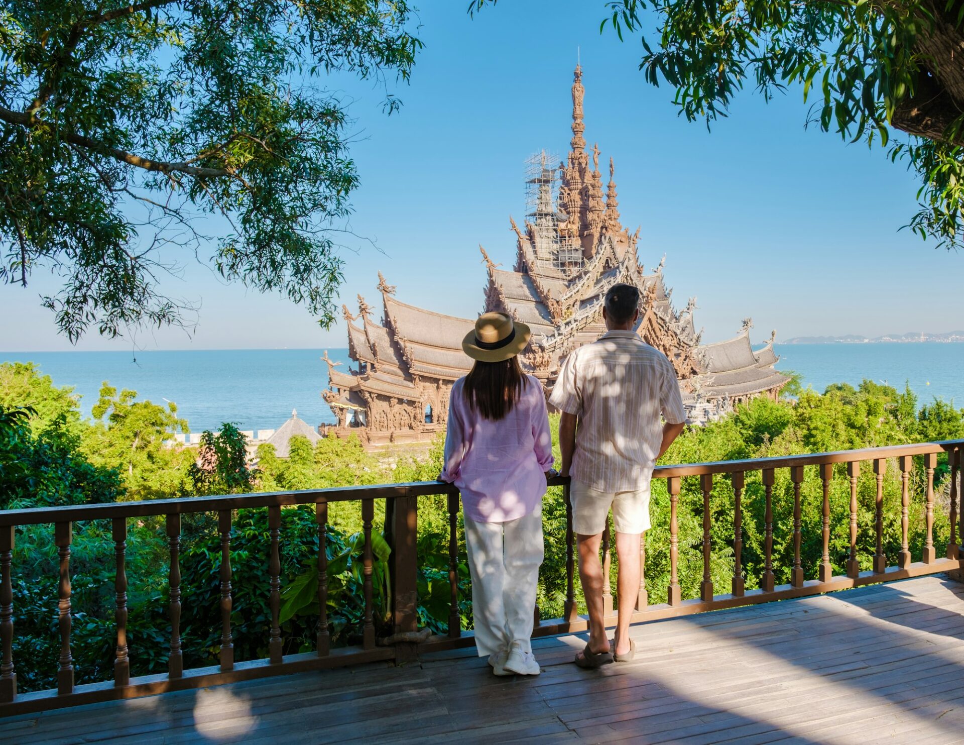 A couple visit The Sanctuary of Truth wooden temple in Pattaya Thailand