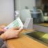 hands with money at bank or currency exchanger