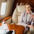 happy businesswoman holding champagne glass in private plane