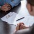 partial view of couple at table with divorce documents
