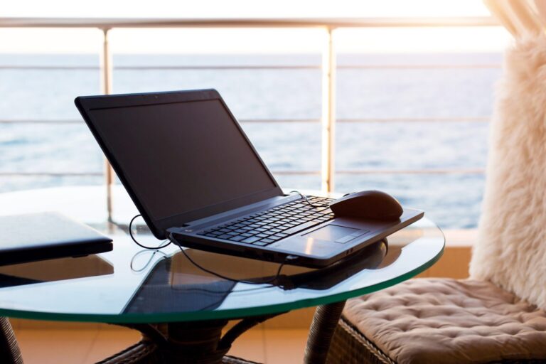 Laptop on the table on the hotel balcony with sea view. Remote work, doing business